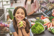 © Yakobchuk Olena - Hilarious smiling girl keeping fruit in shop