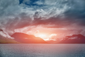 Wall Mural - Travel to Iceland. beautiful sunset over the ocean and fjord in Iceland. Icelandic landscape with mountains, sky and clouds.