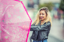 Attractive Young Woman With Pink  Umbrella In The Rain And Strong Wind. Girl With Umbrella In Autumn Weather