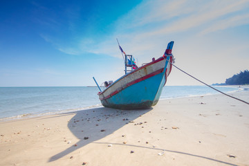 old wooden fishing boat thailand beach with blue sky