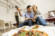 © BGStock72 - Young couple enjoying eating pizza and watching tv