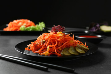 Wall Mural - Plate with delicious spicy carrot spaghetti on table