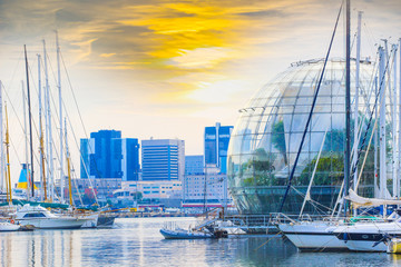 View of the port of genoa dominated by an aquarium and the biosphere greenhouse design with sunset sky.