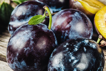 Wall Mural - Fresh plums with leaveson a dark wood background. toning. selective focus