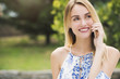 © PhotoPlus+ - Beautiful Young Woman is feeling happy while talking to the phone, outdoors