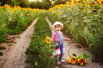 Portrait of a girl with a bouquet of sunflowers . The girl sitting on the road with flowers sunflower