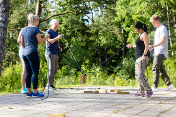 Full Length Of Friends Picking Wooden Blocks With Ropes