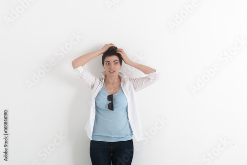 Fotografie, Obraz The confused young woman has clasped hands a head on white background