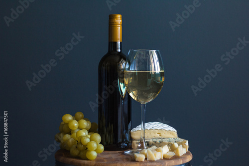 butelka-i-szklo-z-bialym-winem-w-towarzystwie-winogron-i-sera-camembert