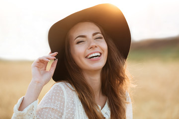 Beautiful young happy woman standing in the field