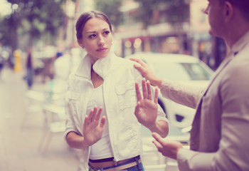 Wall Mural - Unhappy girl getting rid of unwelcome stranger outdoors