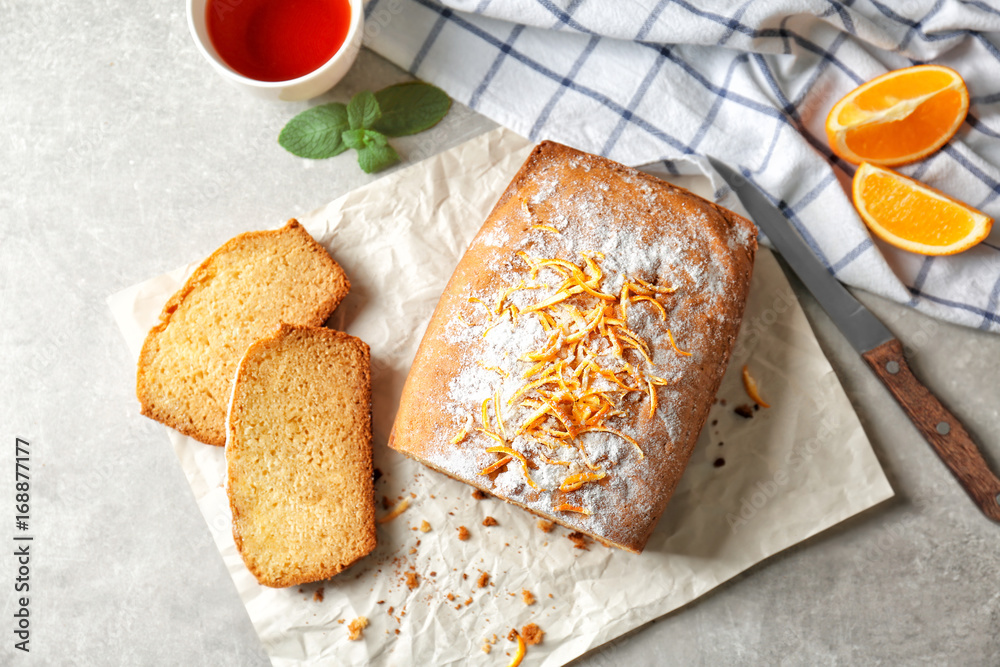 Delicious sliced citrus cake on grey table