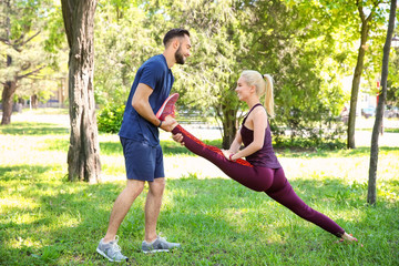 Sticker - Young couple practicing sport exercises for legs in park