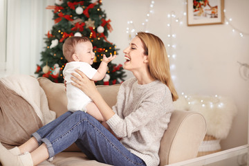 Poster - Happy young mother with baby in decorated room for Christmas