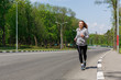 © Prostock-studio - Young woman jogging on road, copy space