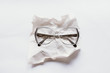 © azulclaritocasiblanco/Stocksy - reading glasses on a wrinkled paper sheet