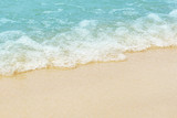 Fototapeta Morze - Soft wave of blue ocean on sandy beach. Background.