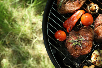 Tasty steaks and vegetables on barbecue grill outdoors