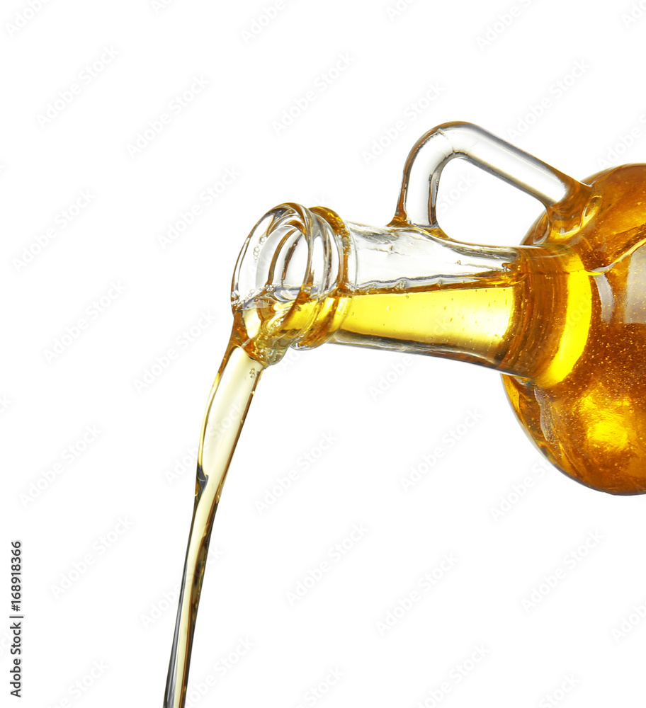 Pouring cooking oil from jug on white background