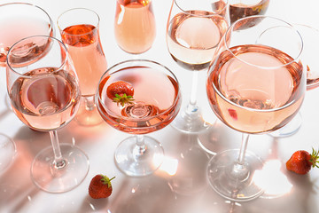 Poster - Many glasses of strawberry wine on white background