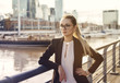 © xo4uphoto - Business woman in suit standing near the river city background