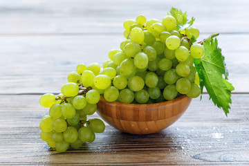 Wall Mural - Bunch of white grapes in a wooden bowl.