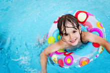 Little Girl In Swimming Pool With Float Ring