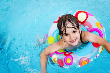 little girl in swimming pool with float ring