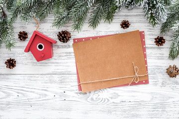 Space for new year greeting. Paper near christmas toys, spruce branch on light background top view mockup copyspace