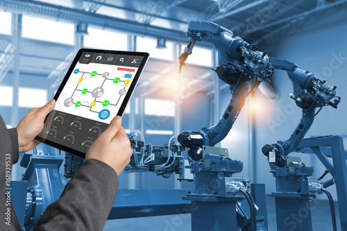 Fotografía Engineer hand using tablet, heavy automation robot arm machine in smart factory industrial with tablet real time process control monitoring system application