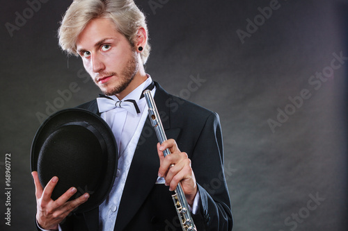 Plakat Elegancko ubrany muzyk trzyma flet