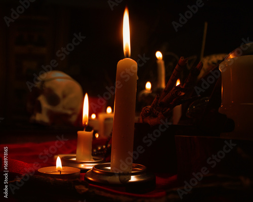 Fotomural Burning candles and human skull. Halloween and occult concept.