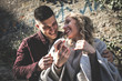 © liderina - Happy couple outdoor. Young couple having funny conversation. Using smart phone.