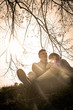 © liderina - Happy couple sitting on the hill and enjoying in beautiful day. Young couple having fun on the grass.