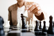 business executive playing chess on board in office, strategy and competition concept