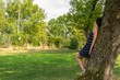 © Żora - Young woman standing by the tree in park