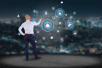 Poster - businessman in front of a wall with a business network connection displayed on a futuristic interfac