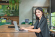 © porama - Beautiful  business woman while sitting at her desk in office typing on her laptop computer.