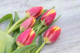 Fototapeta Tulipany - Spring Red and Yellow Tulips on Wood Table