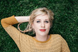 © Vera Lair/Stocksy - Young blond woman lying in grass