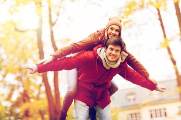 Wall Mural - happy young couple having fun in autumn park