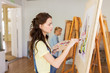 © Syda Productions - student girl with easel painting at art school
