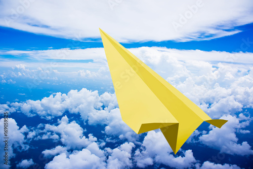 yellow-paper-plane-flying-against-blue-sky