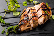 Roasted Chicken Breast on a Black Stone Plate with Balsamic Vinegar and Oregano