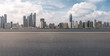 © zhouyilu - Road pavement and city skyline