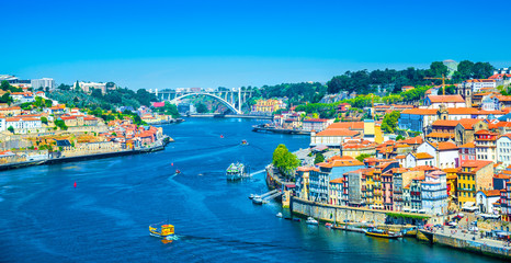 Wall Mural - Beautiful panoramic view over Dom Luis I bridge and traditional boats on Rio Douro river in Porto, Portugal