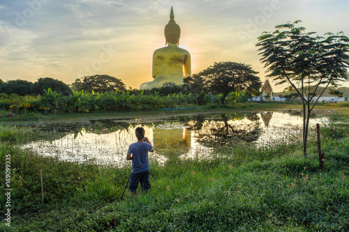 Photo Photographer take a photo with big buddha in wat muang background at Ang Thong Province popular buddhist shrine in Thailand