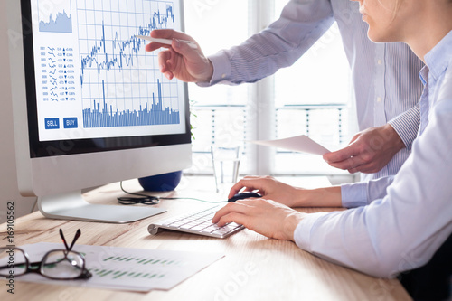 Traders With Forex Trading Charts And Graphs On Computer Screen - 