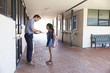 © Monkey Business - School teacher showing book to schoolgirl outside classroom