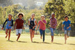 © Monkey Business - Six pre-teen friends running in a park, front view, close up